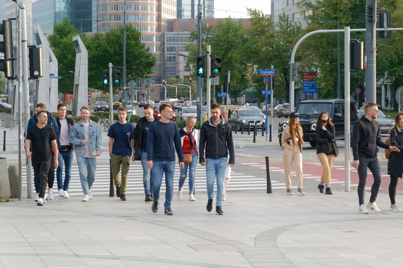 10 - A pedestrian crossing in Warsaw, Poland, where a crowd of residents is navigating a busy city street